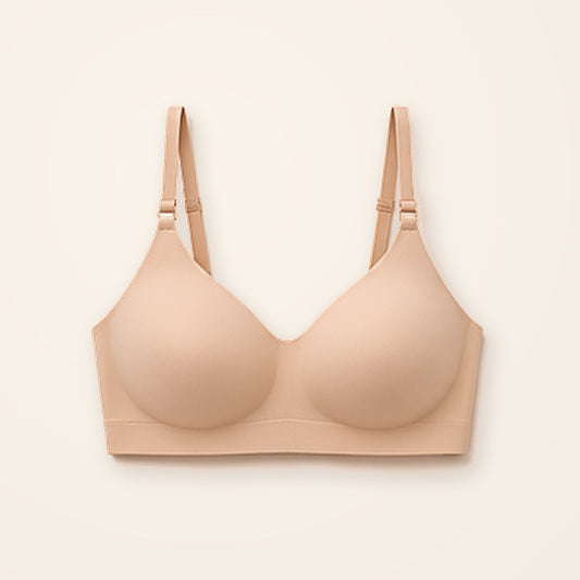 Sostén camiseta nude sin costuras con tirantes ajustables, sobre fondo crema