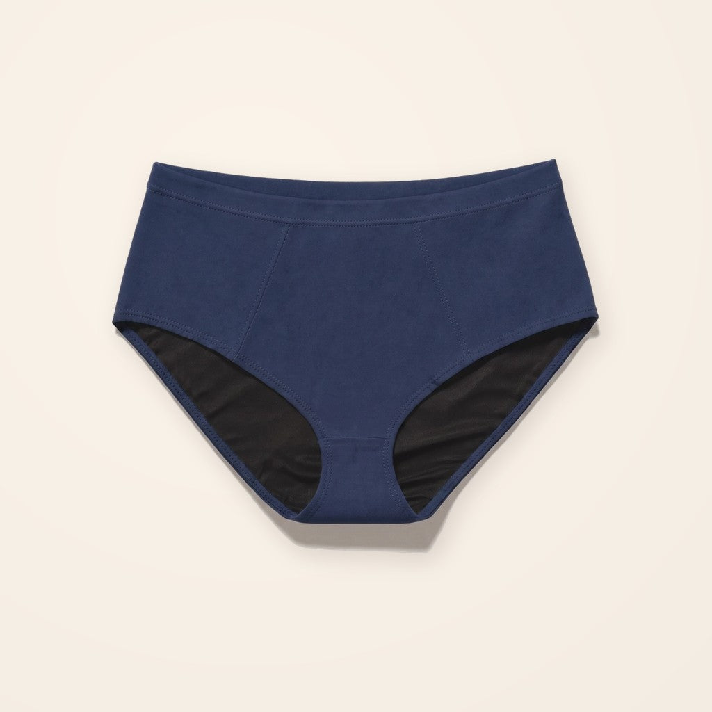 Panty para incontinencia azul marino de tiro alto con entrepierna absorbente, sobre fondo crema