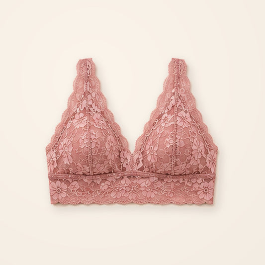 Bralette de encaje rosa con banda ancha y suave, sobre fondo crema