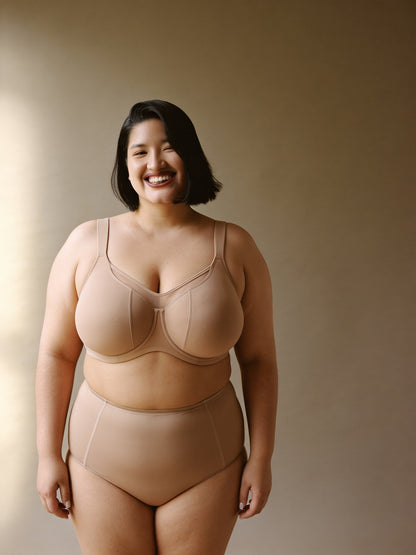 Sostén minimizer beige, vista frontal en modelo con panel de malla y costuras en la copa