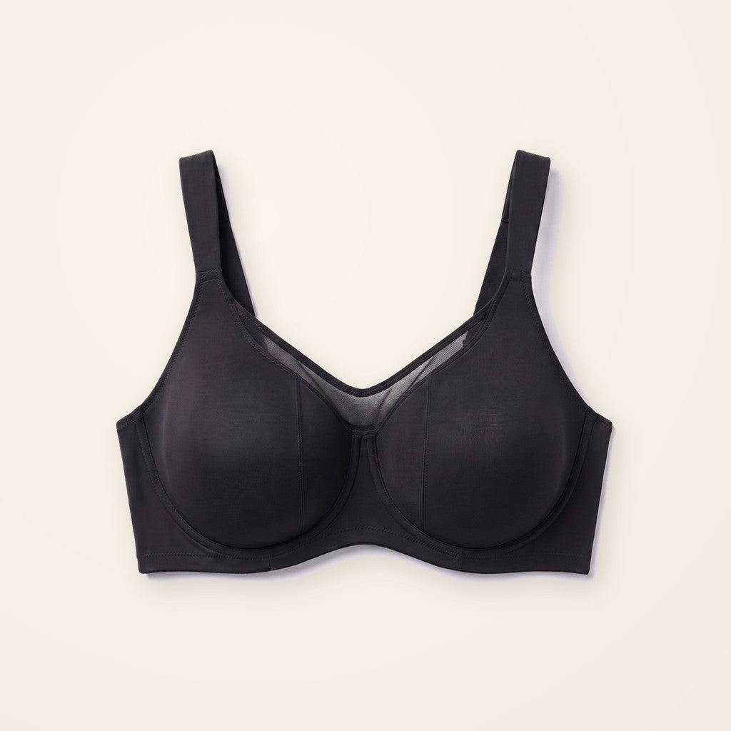 Sostén minimizer negro con panel de malla, sobre fondo crema